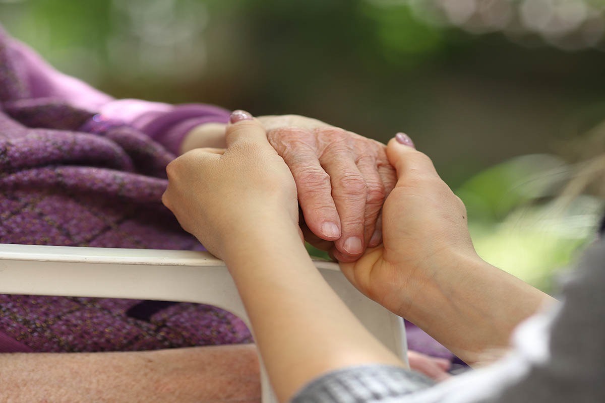 Holding an older person's hands
